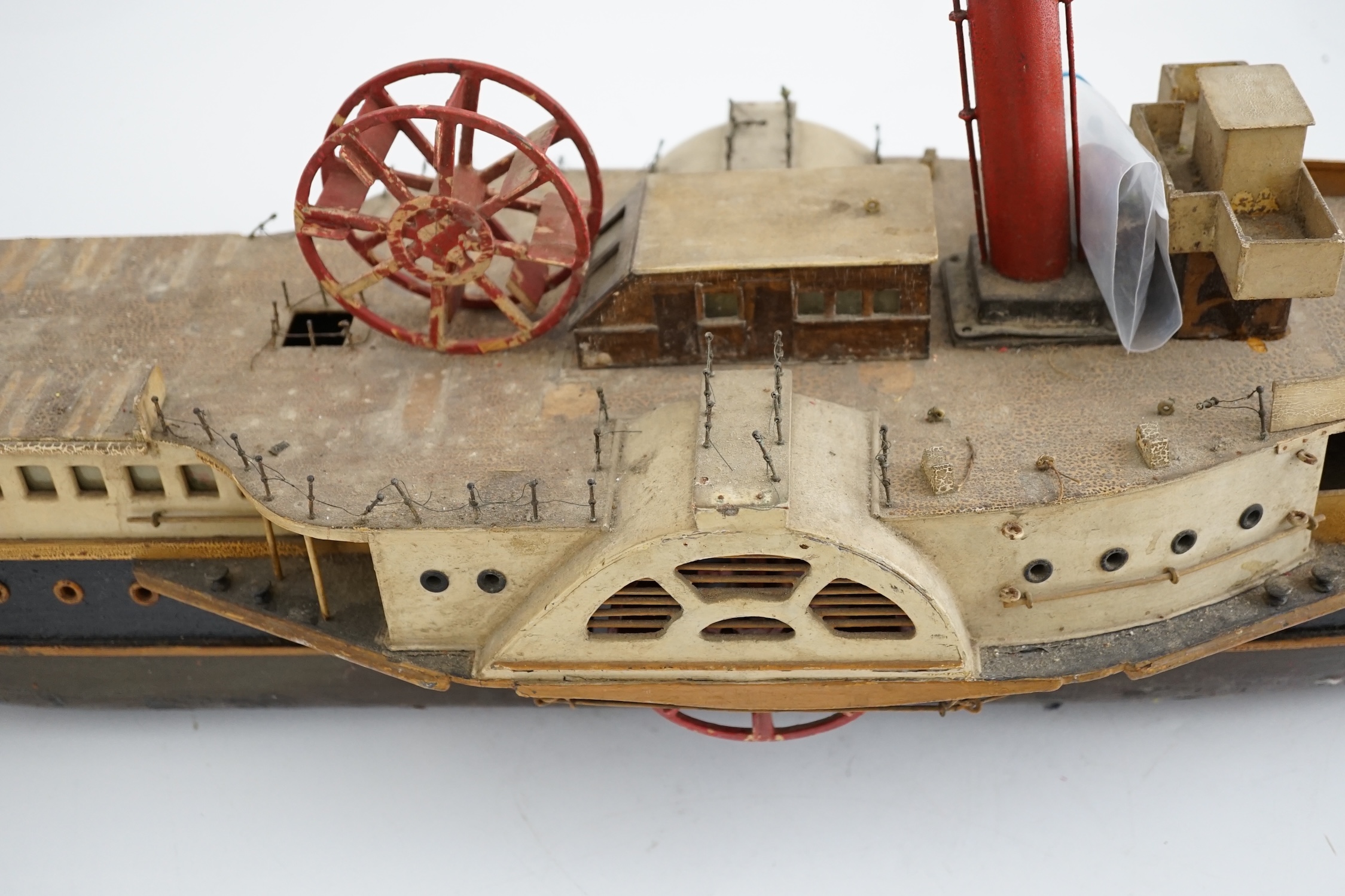 A wooden model of a paddle steamer, with a well detailed deck and with some age to the model, however now requiring some restoration, 80cm long